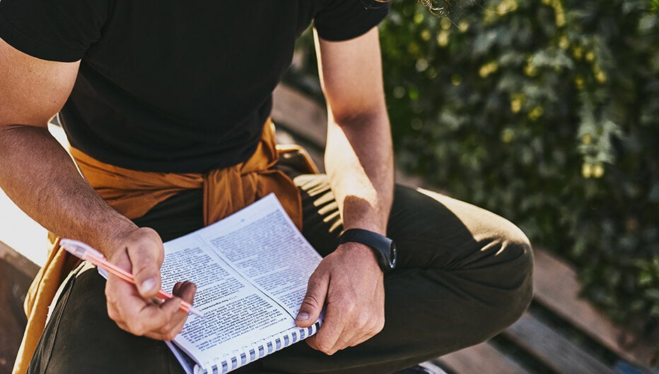 man typing down notes